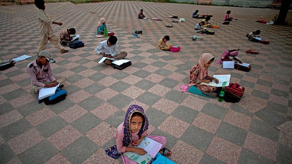 Pakistani children being taught in a public park (photo: AP)