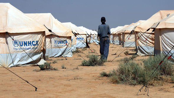 Ein Mann läuft zwischen Zelten der UNHCR