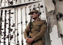 Soldat vor Wand mit Einschusslöchern nach einem Feuergefecht mit Al-Qaida-Aktivisten; Foto: dpa 