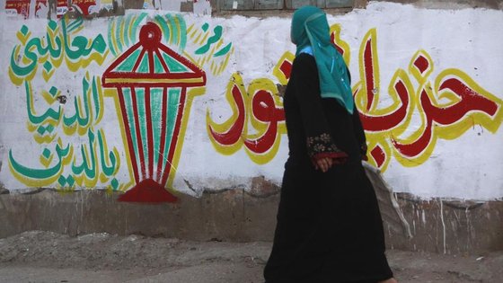 Ägypterin passiert Wand mit Wahlwerbung der islamistischen Nour-Partei in El-Qalubia; Foto: Reuters