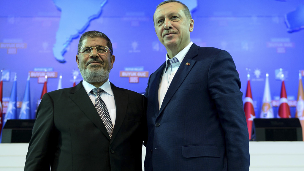 Turkey's Prime Minister and leader of ruling Justice and Development Party (AKP) Tayyip Erdogan (R) and his guest Egypt's President Mohamed Mursi greet the audience during AK Party congress in Ankara September 30, 2012 (photo: Kayhan Ozer/Prime Minister's Press Office/Handout/Reuters)