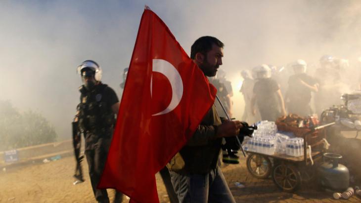 متظاهر يرفع العلم التركي في حديقة غيزي في اسطنبول. بتاريخ 15 يونيو 2013. photo: Murad Sezer/Reuters