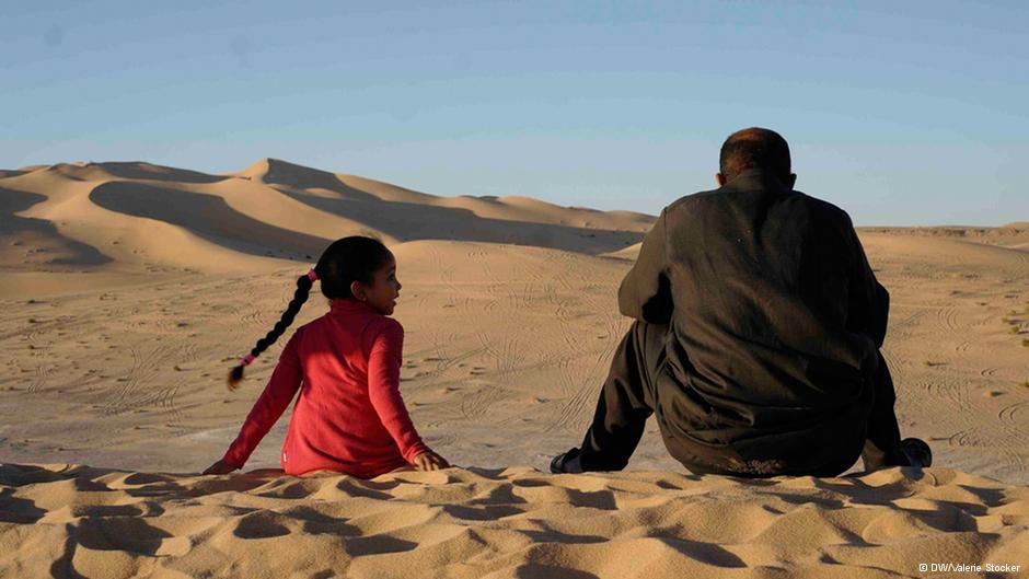 Ein Mann und ein Mädchen in der libyschen Wüste; Foto: Valerie Stocker/DW