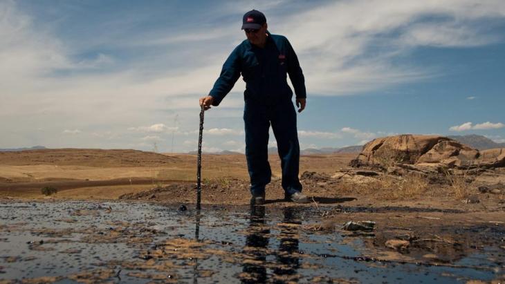 رجل يقف على حقل نفط في كردستان العراق. Photo: dpa