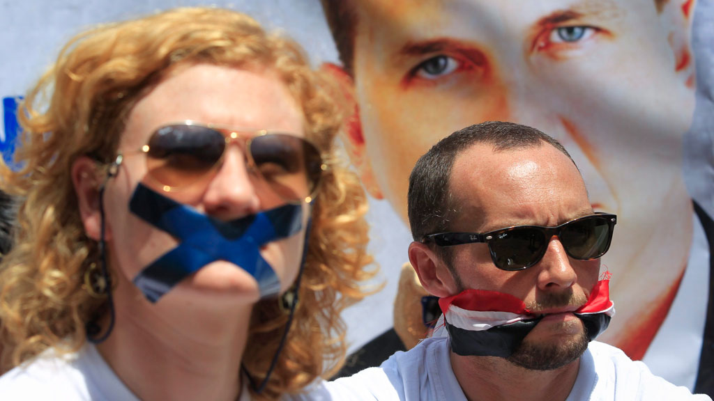 Journalists Phil Moore (rechts) und Jessica Hatcher protestieren gegen die Inhaftierung eines Mitarbeiters von Al-Dschasira English; Foto: picture-alliance/dpa