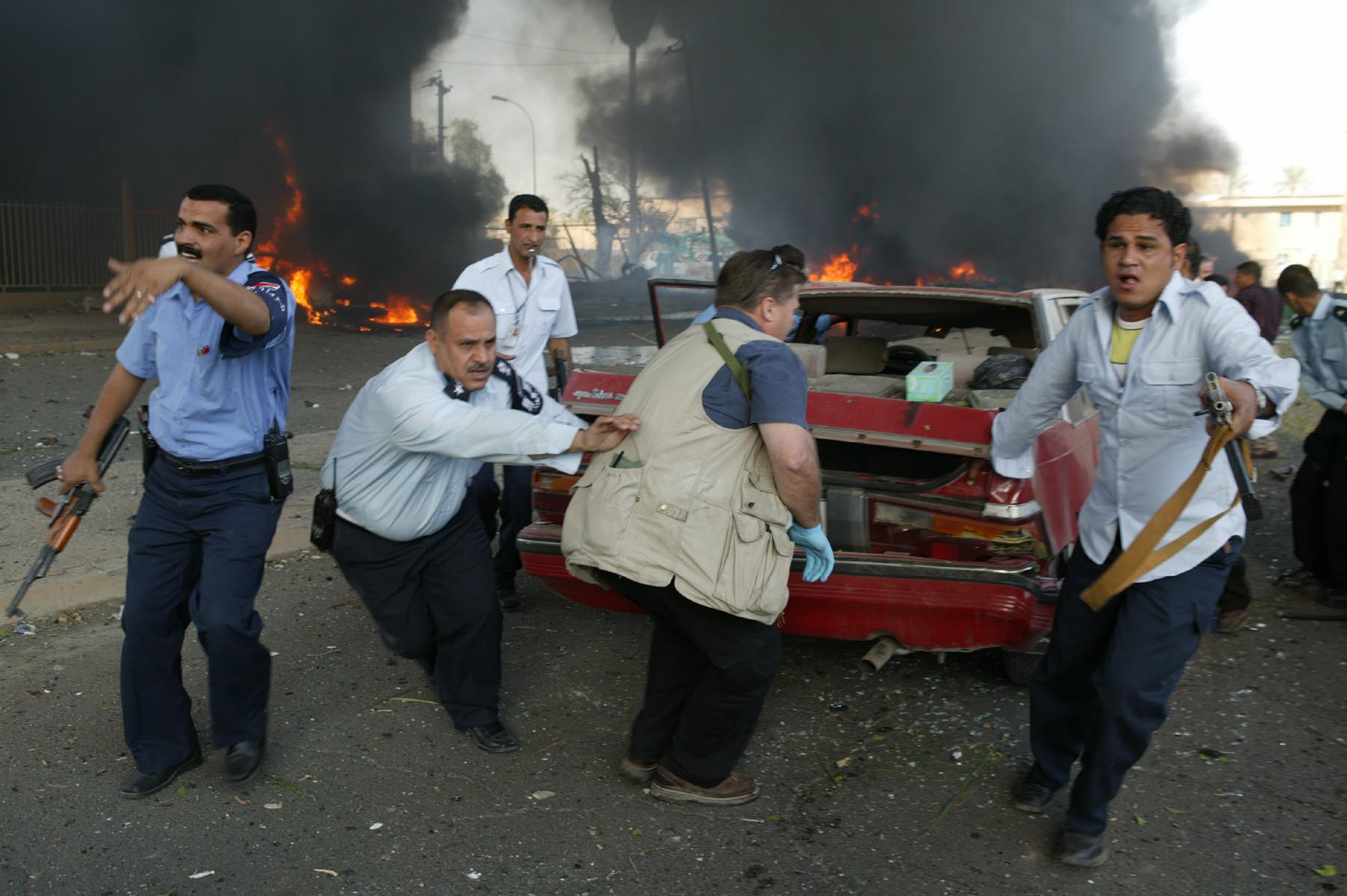 Men dragging a car from the scene of a suicide car bombing of the International Red Cross building in Baghdad, 27 October 2003 (photo: Michael Kamber)