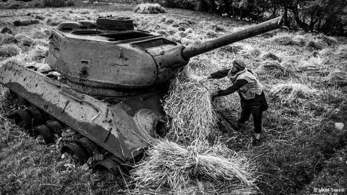 Ein afghanischer Bauer lädt seine Ernte auf einen noch aus der sowjetischen Besatzungszeit stammenden Panzer; Foto: Majid Saeedi 