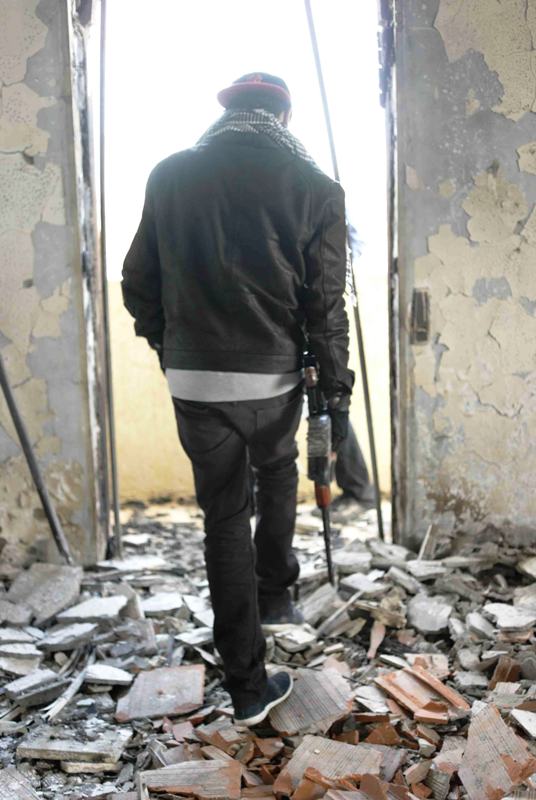 Junger Stammeskämpfer begutachtet in Warschefana zerstörtes Gebäude; Foto: Valerie Stocker