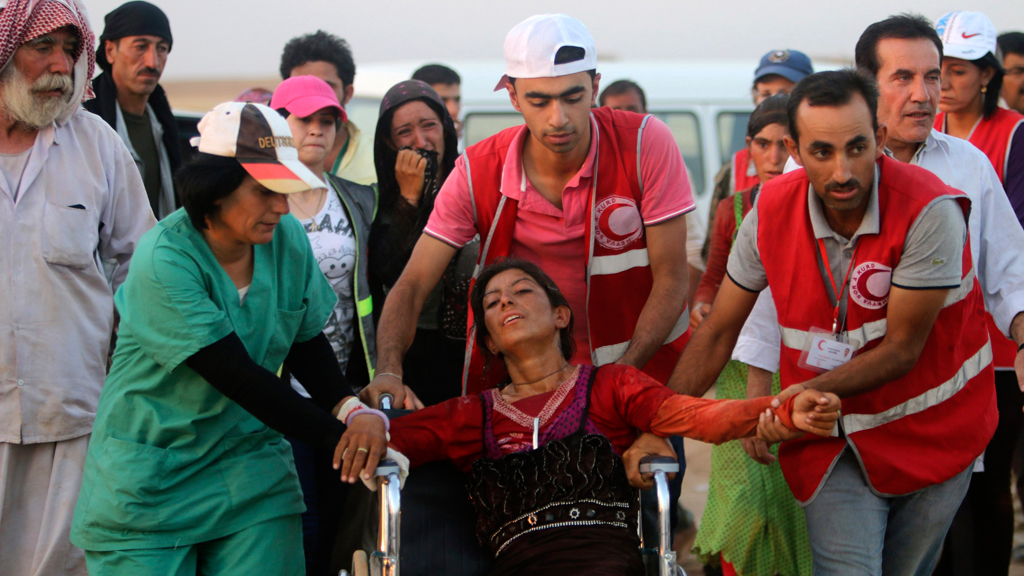 Mitglieder des Kurdischen Roten Halbmondes helfen einer jesidischen Frau; Foto: Reuters