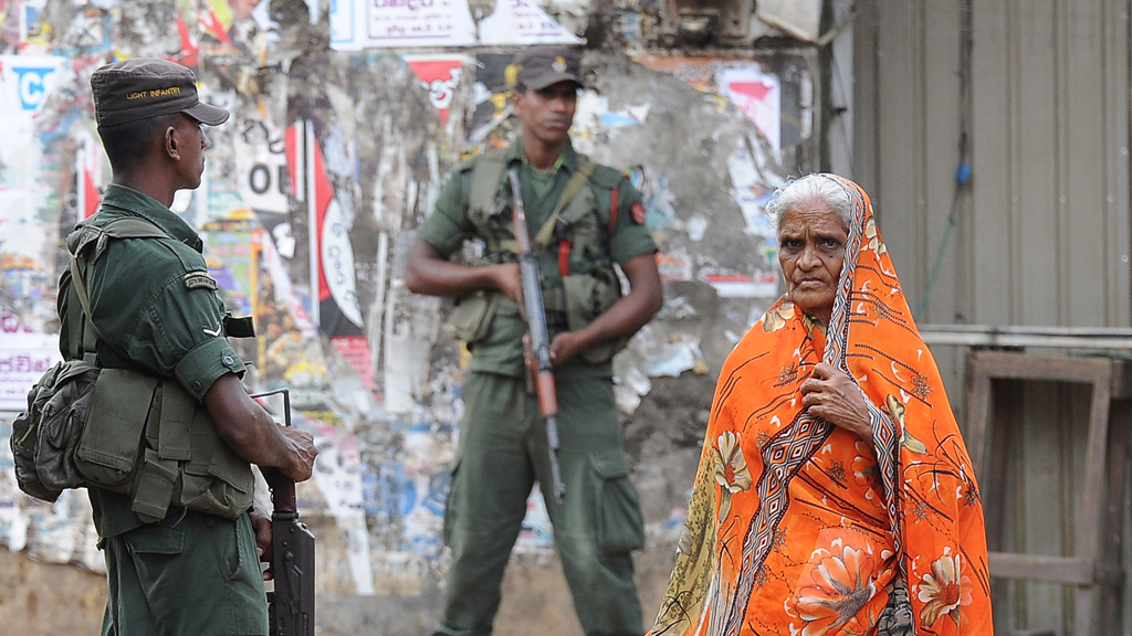 Sri Lankan soldiers stand guard by a roadside following clashes between Muslims and an extremist Buddhist group in the town of Aluthgama, 17 June 2014 (photo: Lakruwan Wanniarachchi/AFP/Getty Images)