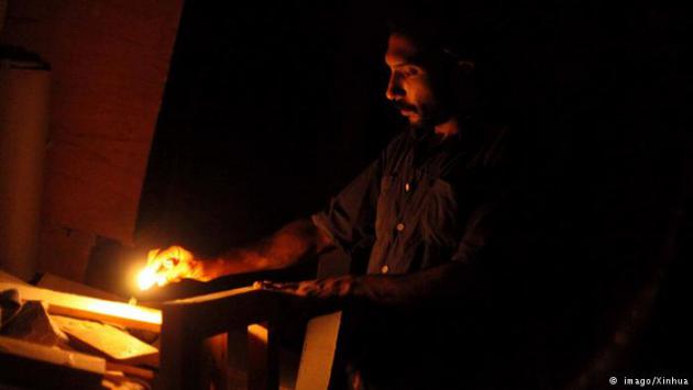 A man lighting a candle (photo: imago/Xinhua)