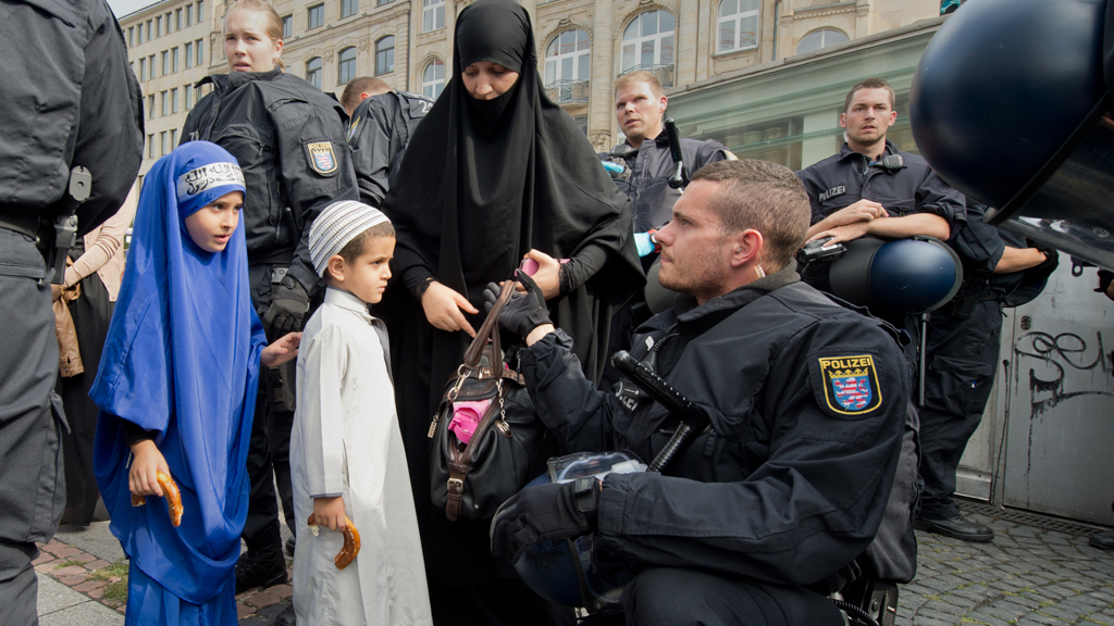 Anhängerin von Pierre Vogel bei Taschenkontrolle durch Polizisten vor der Kundgebung am 07.09.2014; Foto: picture-alliance/dpa/B. Roessler