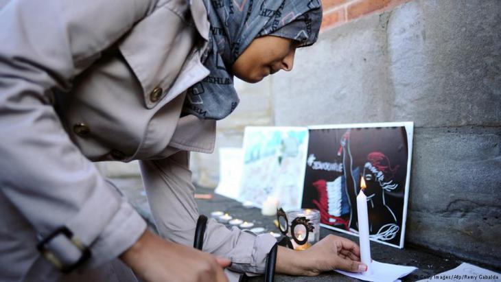 A Muslim woman lights a candle for the victims of the Paris attacks (photo: AFP/Getty Images)