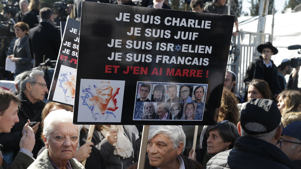 Mourners at a Jerusalem cemetery on 13 January 2015 attend the funeral of four Jews killed in the attack on a kosher supermarket in Paris the previous week. The French slogans on the placard read: "I'm Charlie, I'm Jewish, I'm Israeli, I'm French, I'm fed up." (photo: AFP/Getty Images/J. Guez)