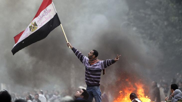 A man waving an Egyptian flag during a riot (photo: AFP/Getty Images/M. Abed)