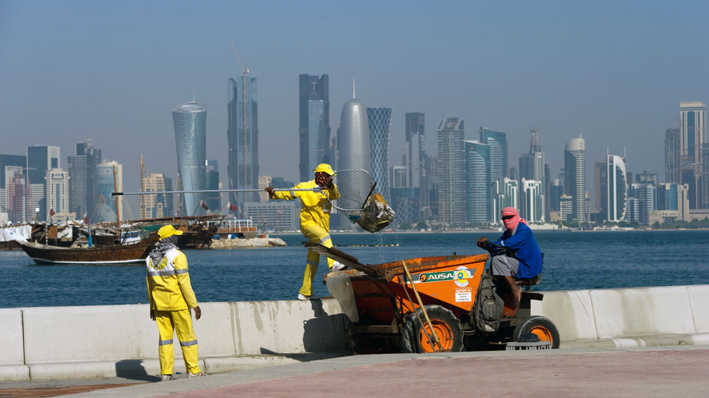 Arbeiter fischen in Doha Müll aus dem Meer. Foto: picture-alliance/ dpa