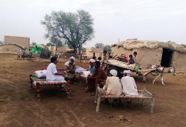 Men sitting on charpoys outside their homes, Cholistan desert, Pakistan (photo: Usman Mahar)