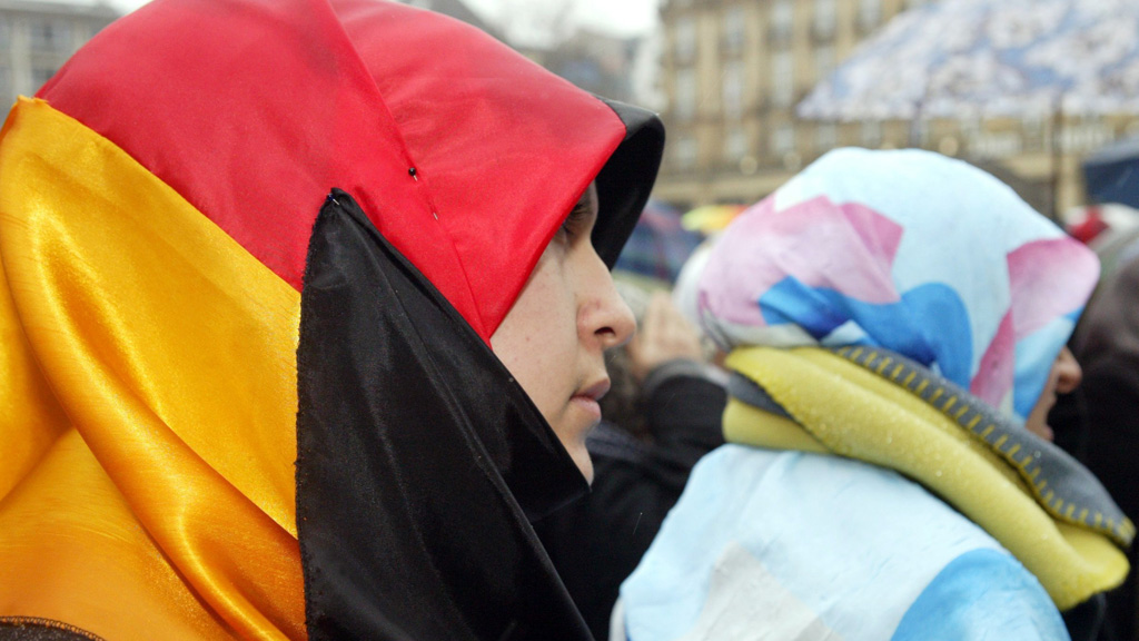 Frau mit Deutschland-Flagge auf einer Demonstration gegen das Kopftuchverbot und "Pseudo-Pressefreiheit" in Deutschland. Foto: picture-alliance/dpa