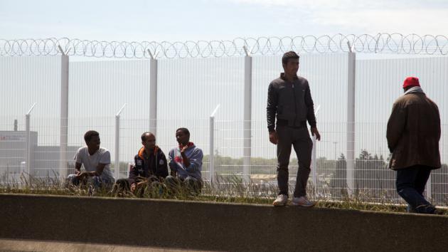 Refugees near a security fence in Calais (photo: DW/L. Scholtyssek)