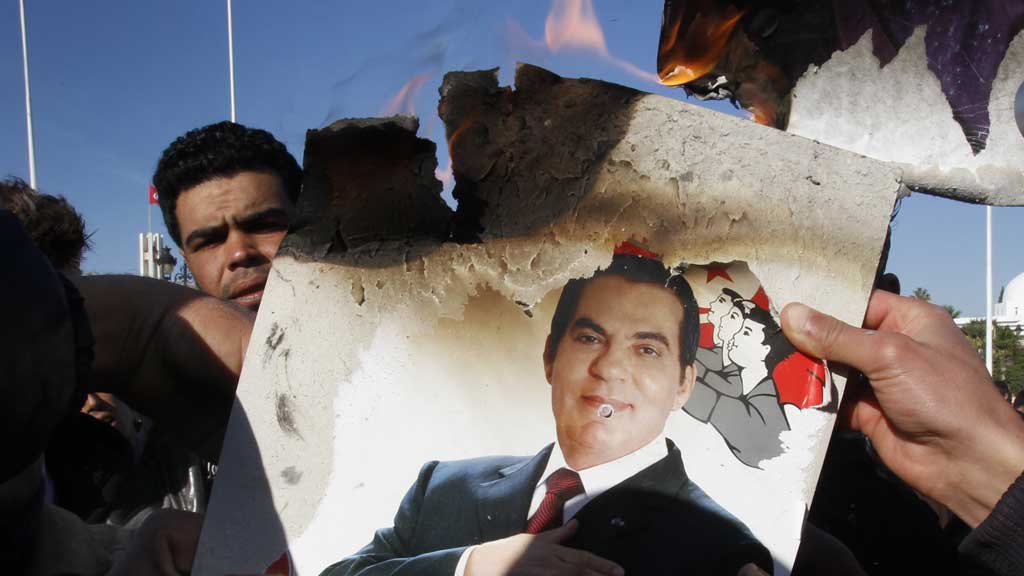 In Tunis verbrennen Demonstranten ein Bild von Zine El Abidine Ben Ali; Foto: dpa