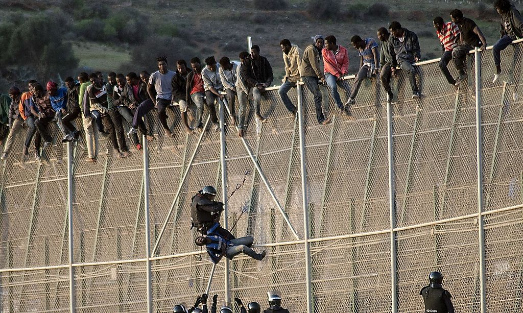 Polizisten versuchen Flüchtlinge von dem Zaun in Melilla zu holen; Foto: Reuters