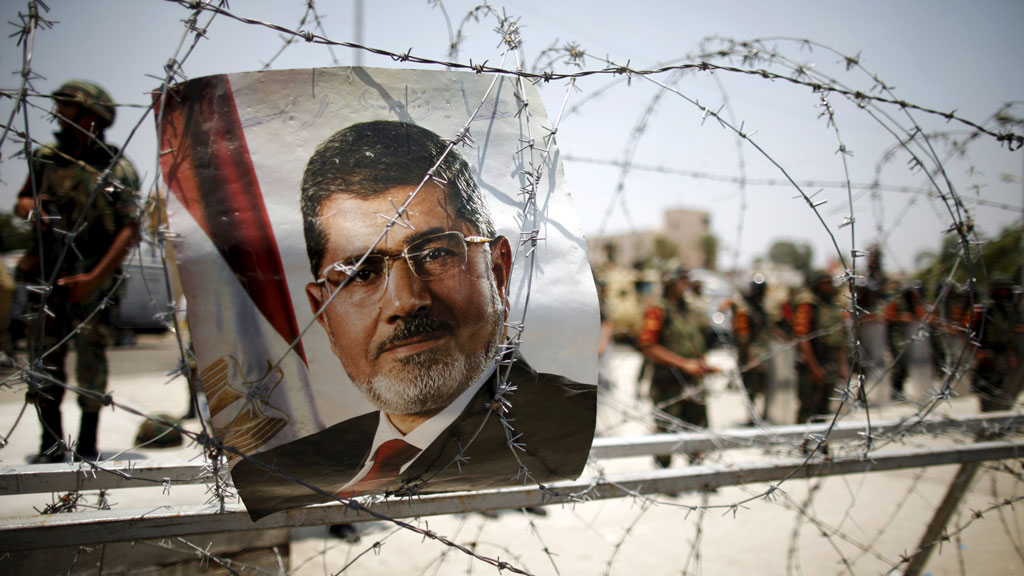 Plakat Mursis vor einer Absperrung des ägyptischen militärs in Kairo; Foto: picture-alliance/dpa/K. Elfiq 