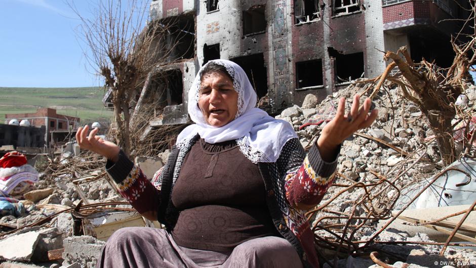 Eine Frau in den Trümern ihres zerstörten Hauses; Foto: DW 