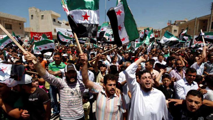 Syrians attend an anti-Assad demon following Friday prayers in the rebel stronghold of Idlib (photo: AP)