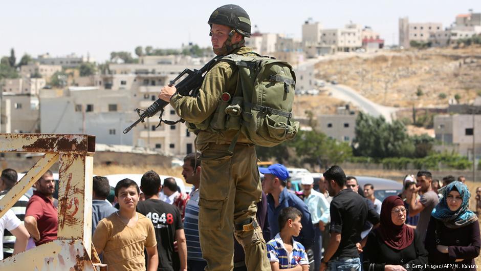 Israelischer Soldat bewacht einen Checkpoint vor wartenden Palästinensern im Süden Hebronsr guarding a checkpoint south of Hebron