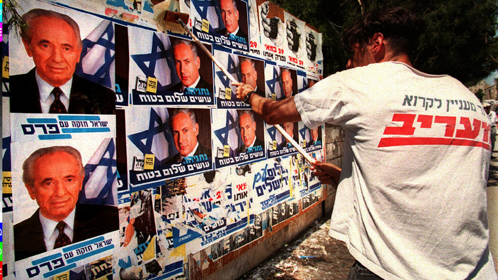Ein Aktivist des rechten Likud überklebt Wahlplakate des israelischen Ministerpräsidenten Schimon Peres am 26.5.1996 in Jerusalem mit denen des Likud-Führers Benjamin Netanjahu; Foto: picture-alliance/COLORplus/P. Guyot