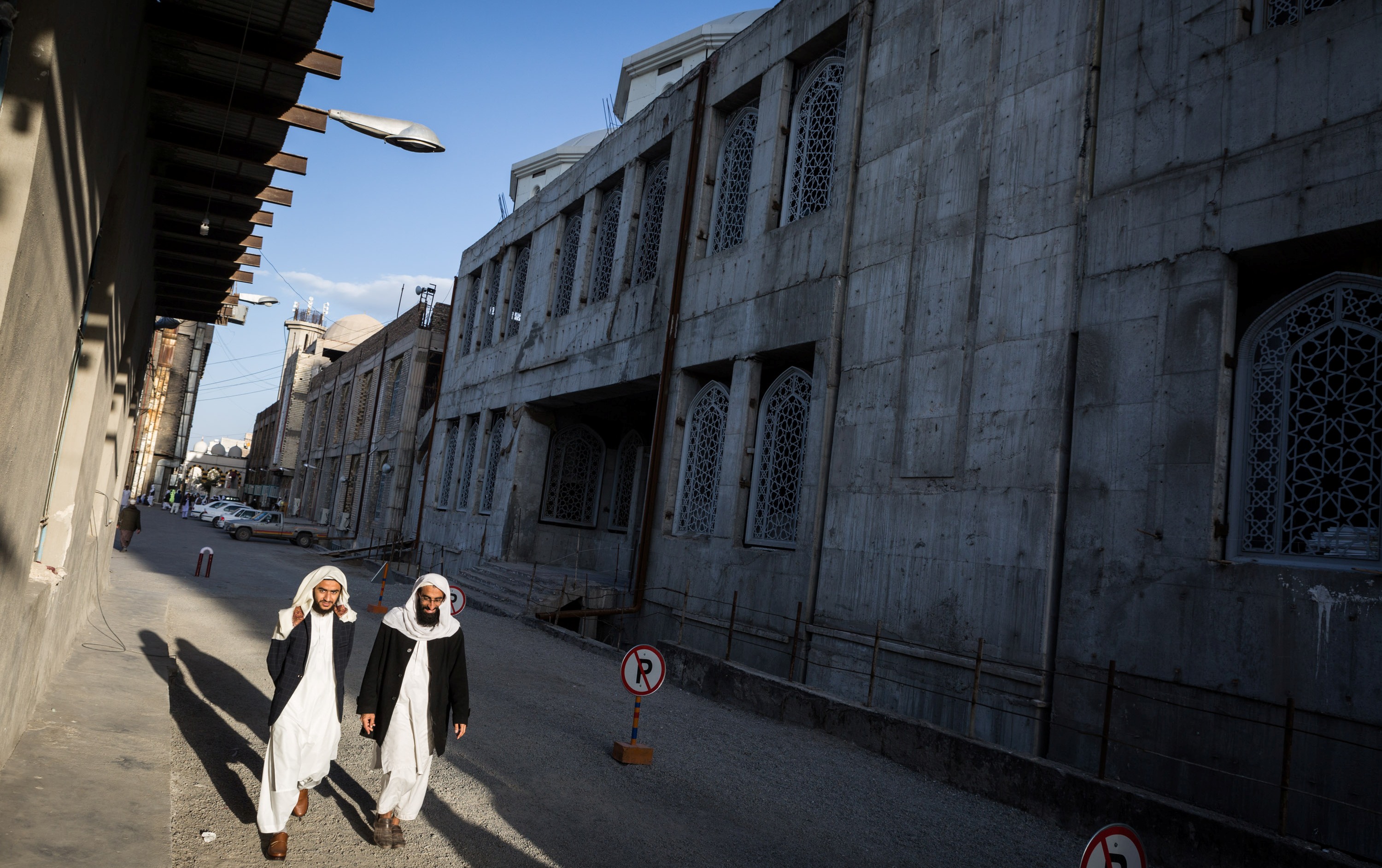 Zwei Schüler der Jamiah Darul Uloom spazieren neben dem Rohbau der Makki-Moschee in Zahedan; Foto: Philipp Breu