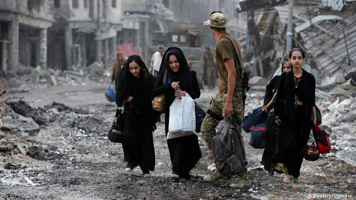 People walk through a destroyed neighbourhood of Mosul (photo: Reuters/Stringer)