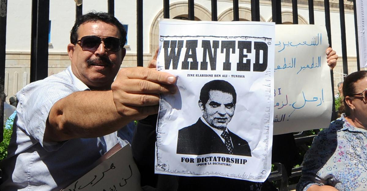 Tunesier hält Plakat mit der Aufschrift "Wanted: Ben Ali - Tunesien"; Foto: AFP