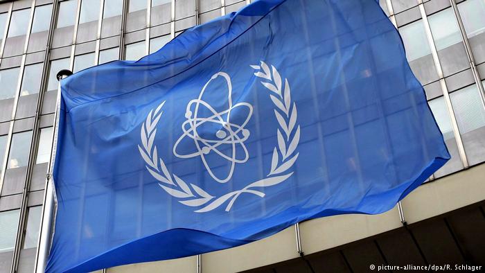 A flag bearing the symbol of the International Atomic Energy Agency (IAEA) waves outside the UN building in Vienna