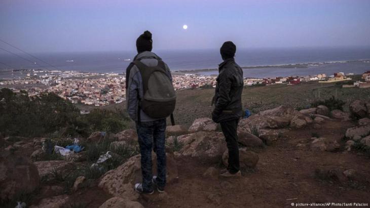 Flüchtlinge in der marokkanischen Provinz Nador blicken auf die spanische Exklave Melilla, Foto: picture-alliance/AP