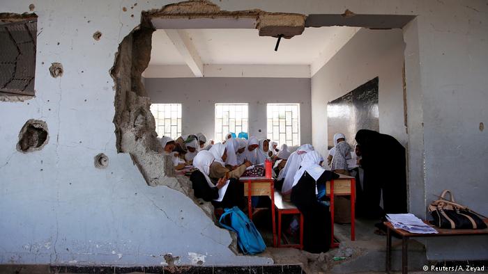 Girls with white headscarves in a ruined Yemeni classroom (photo: Reuters/A. Zeyad)