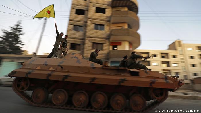 YPG fighters ride on a tank through the town of Qamishli in northeastern Syria, close to the Turkish border (photo: AFP/Getty Images)