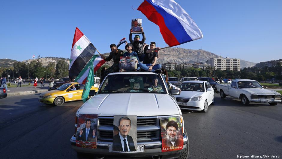 Anhänger Assads schwenken syrische, russische und iranische Fahnen in Damaskus; Foto: picture-alliance/AP