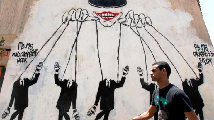 Graffiti in Cairo showing the military as puppet master (photo: Nasser Nasser/AP)