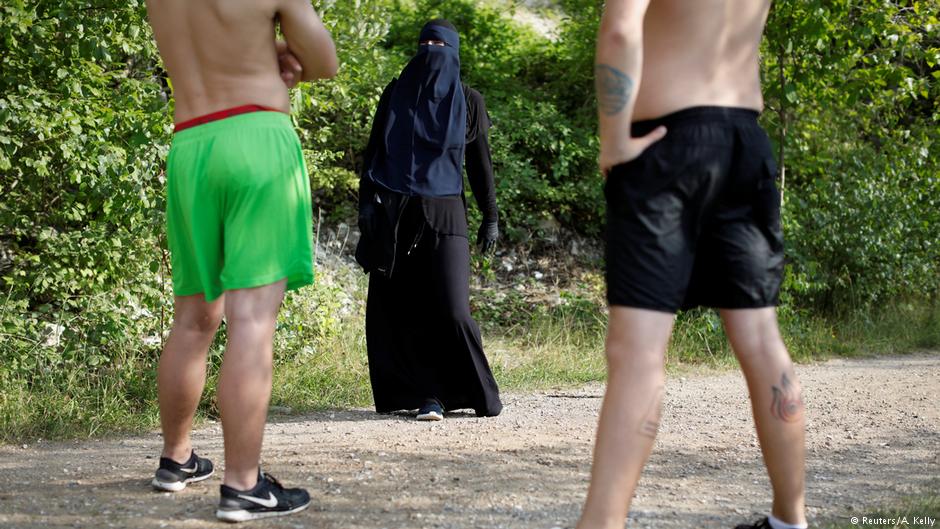 Ayah, 37, a wearer of the niqab, speaks with swimmers during a visit to Karlstrup Kalkgrav, a lake near Karlstrup located outside Copenhagen, Denmark, 18 July 2018 (photo: Reuters/Andrew Kelly)