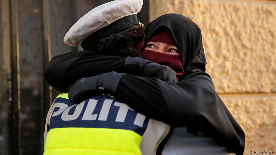 Ayah weeps as she is embraced by a police officer during the demonstration (photo: Reuters/Andrew Kelly)