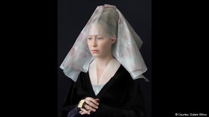 A photograph shows a woman dressed in a Flemish style but with clothing made of recycled materials (photo: Galerie Wilms)
