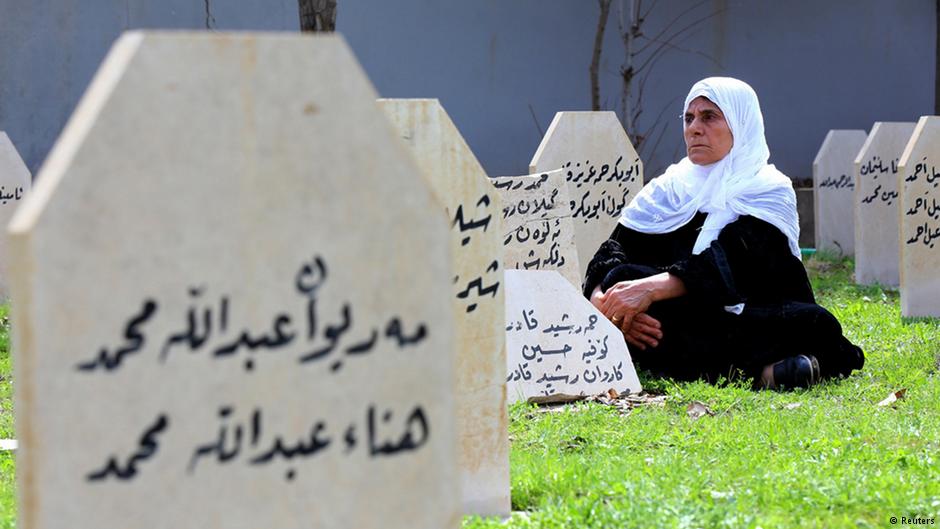 Eine Frau sitzt zwischen den Gräbern auf dem Massenfriedhof für die Halabdscha-Opfer; Foto: Reuters