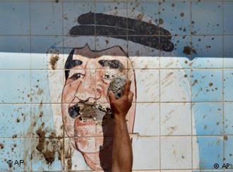 Nach dem Sturz Saddam Husseins zerstört ein Kurde am 10. April 2003 ein Wandbild des Diktators im Nordirak; Foto: AP