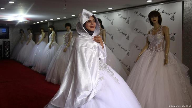 Die Gymnasiastin Hana Abu El-Roos probiert am 26. November 2018 in einem Geschäft in Gaza City ein Hochzeitskleid an; Foto: Reuters/Samar Abo Elouf