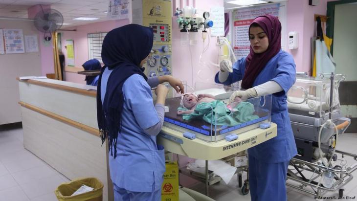 Hebamme Sara Abu Taqea (r.) wiegt ein Neugeborenes auf der Entbindungsstation im Gaza-Krankenhaus Al-Ahli; Foto: Reuters/Samar Abo Elouf
