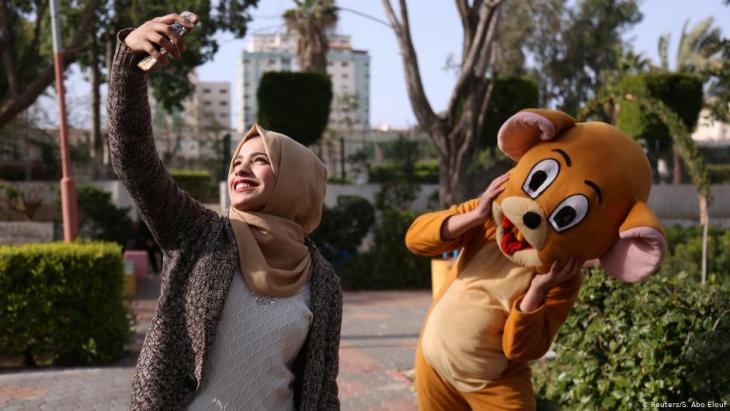 Wessal macht ein Selfie von sich und einer kostümierten Person in einem öffentlichen Park in Gaza City; Foto: Reuters/Samar Abo Elouf
