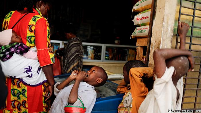 Ein Kind bettelt bei einer Passantin im Senegal; Foto: Reuters