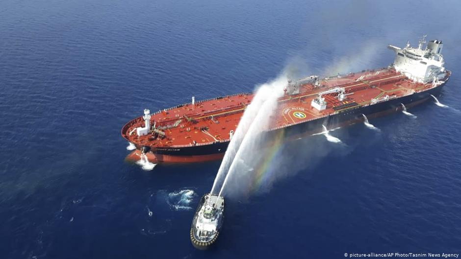 An Iranian navy boat sprays water to extinguish a fire on an oil tanker in the sea of Oman, 13 June 2019 (photo: picture-alliance/AP Photo/Tasnim News Agency)