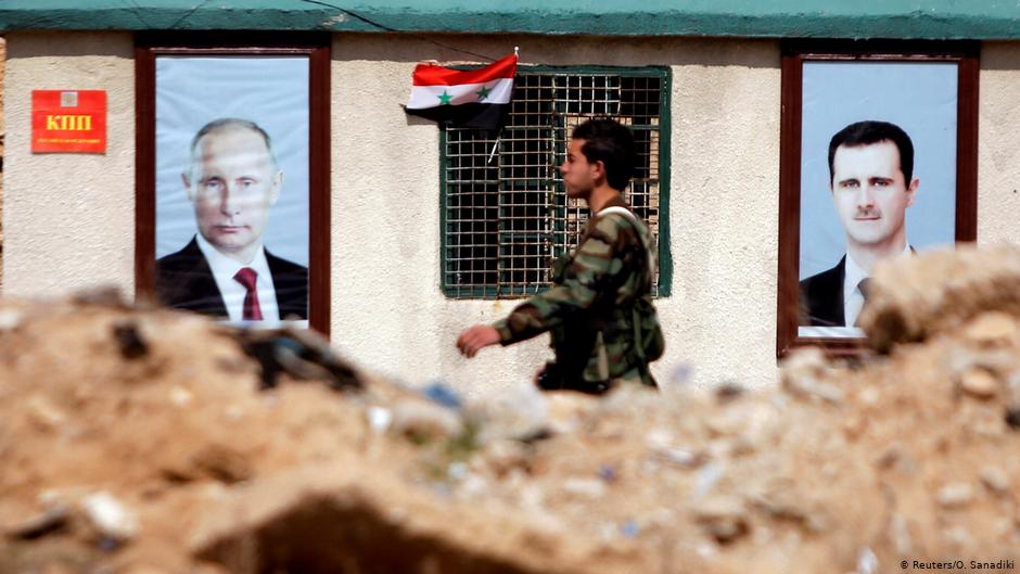 Syrisches Militär vor Putin- und Assad-Porträts in Ost-Ghouta bei Damaskus; Foto: Reuters/Omar Sanadiki
